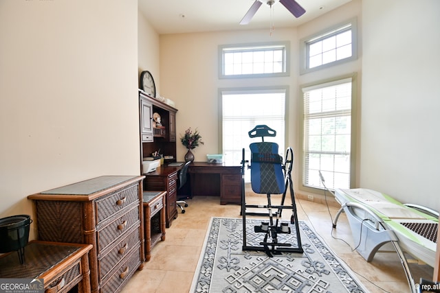 tiled office space with a towering ceiling and ceiling fan