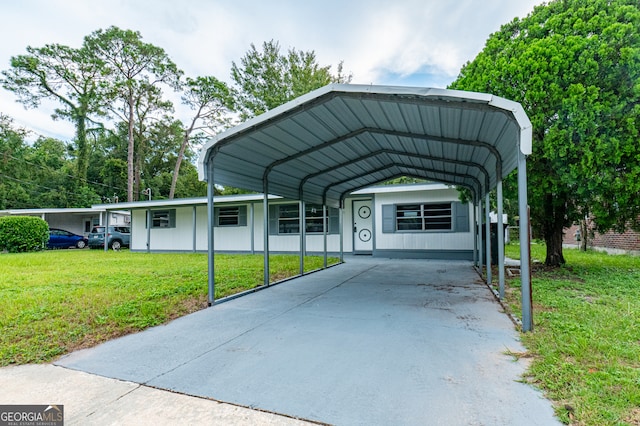 view of parking / parking lot featuring a yard and a carport