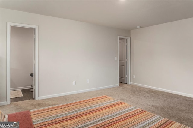 unfurnished bedroom featuring carpet flooring and ensuite bath