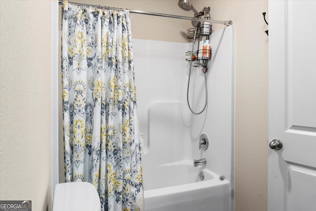 bathroom featuring shower / bath combination with curtain and toilet