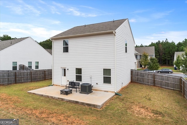 rear view of property featuring cooling unit, a yard, and a patio