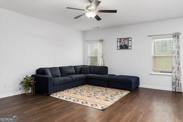 living room featuring ceiling fan and dark hardwood / wood-style flooring