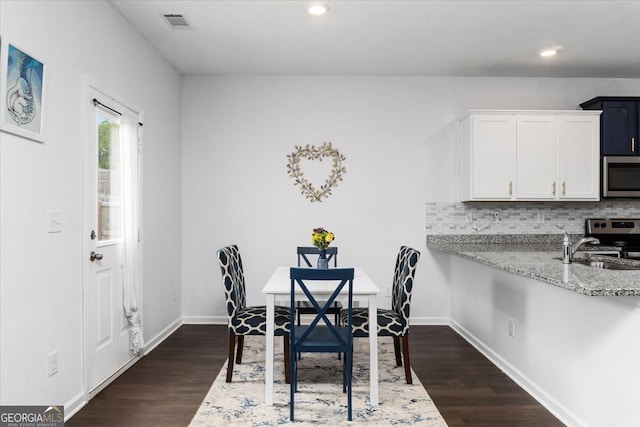 dining room with dark hardwood / wood-style floors and sink