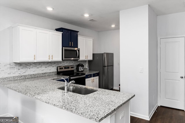 kitchen featuring sink, appliances with stainless steel finishes, kitchen peninsula, and white cabinetry