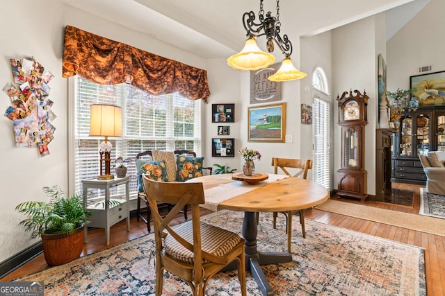 dining room with lofted ceiling, hardwood / wood-style flooring, and plenty of natural light