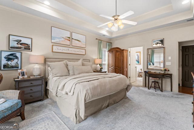 carpeted bedroom featuring ceiling fan, ornamental molding, and a tray ceiling