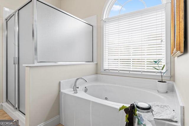 bathroom featuring shower with separate bathtub