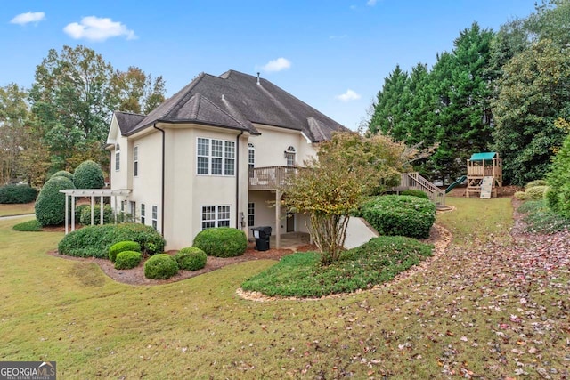 rear view of property featuring a playground, a lawn, and a pergola