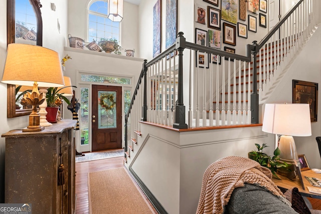 entryway featuring hardwood / wood-style flooring and a towering ceiling