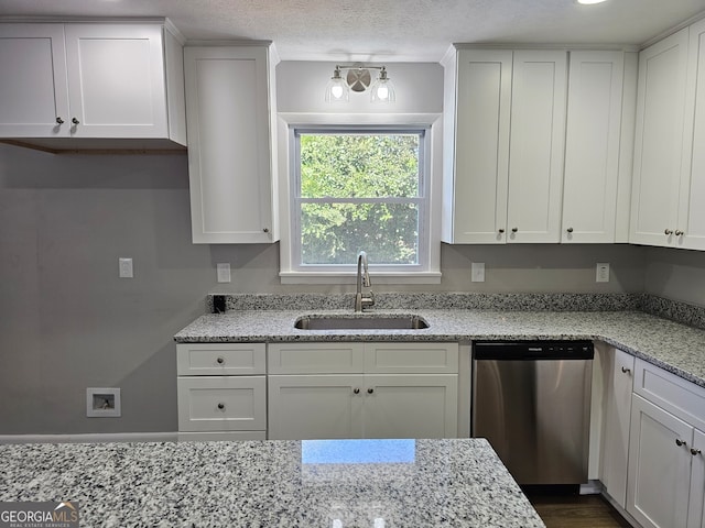 kitchen featuring white cabinets, light stone counters, a textured ceiling, stainless steel dishwasher, and sink