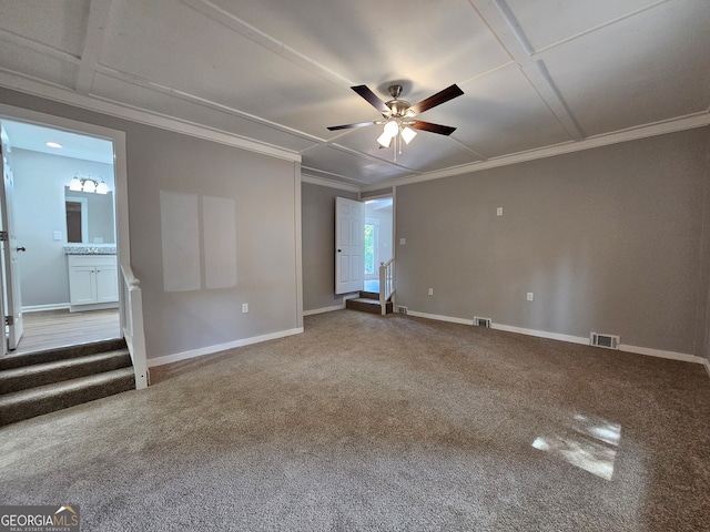 carpeted spare room featuring crown molding, coffered ceiling, and ceiling fan