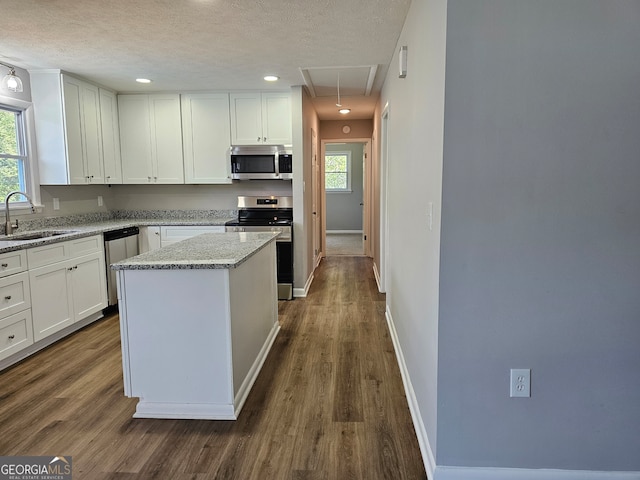 kitchen featuring a wealth of natural light, sink, a center island, and appliances with stainless steel finishes