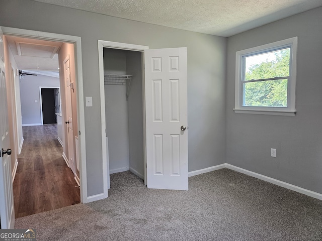 unfurnished bedroom featuring carpet, a textured ceiling, and a closet