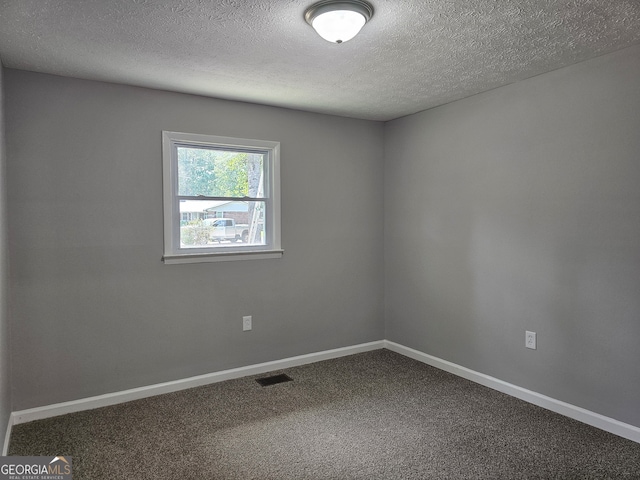 spare room featuring a textured ceiling and carpet