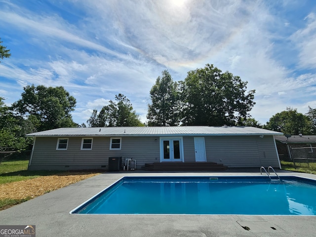 view of pool with french doors, cooling unit, and a patio