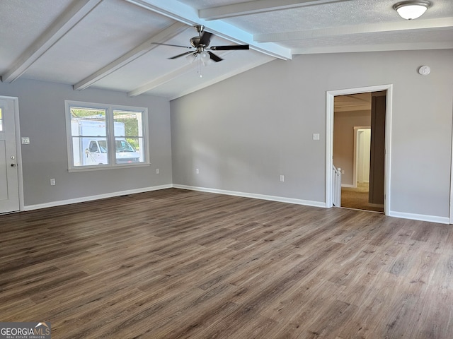 empty room featuring ceiling fan, lofted ceiling with beams, wood-type flooring, and a textured ceiling