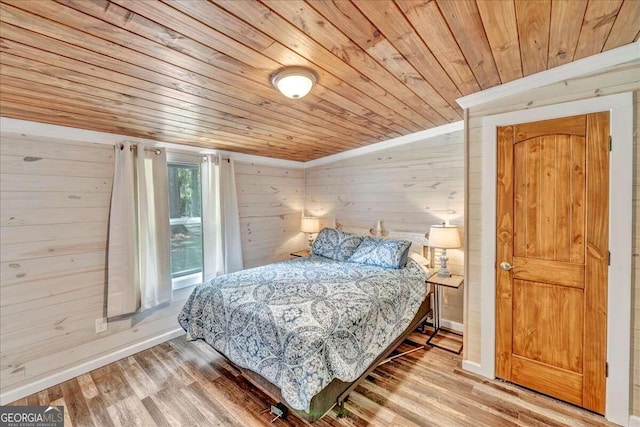 bedroom featuring wood walls, wood-type flooring, and wooden ceiling