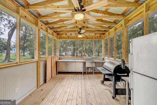 unfurnished sunroom featuring a wealth of natural light and ceiling fan