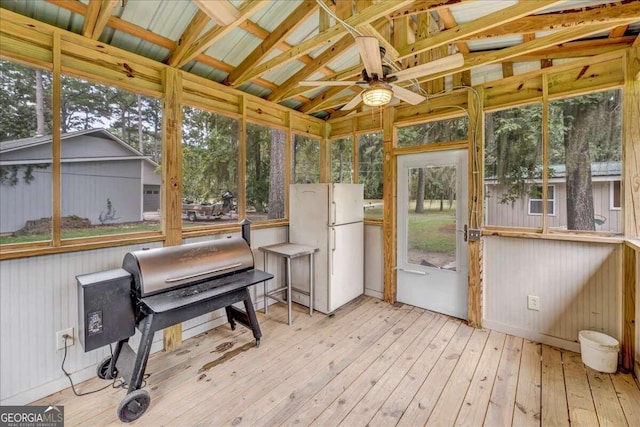 sunroom / solarium featuring plenty of natural light, ceiling fan, and vaulted ceiling