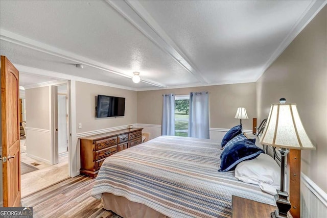 bedroom featuring ornamental molding and light hardwood / wood-style flooring