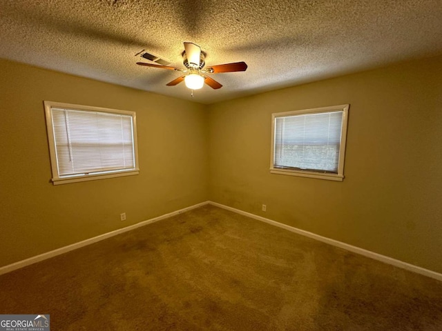 empty room featuring a textured ceiling, a healthy amount of sunlight, ceiling fan, and carpet