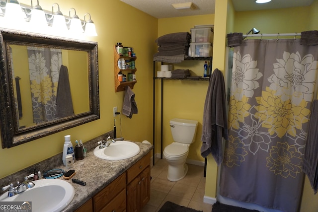 bathroom featuring tile patterned flooring, vanity, toilet, and walk in shower