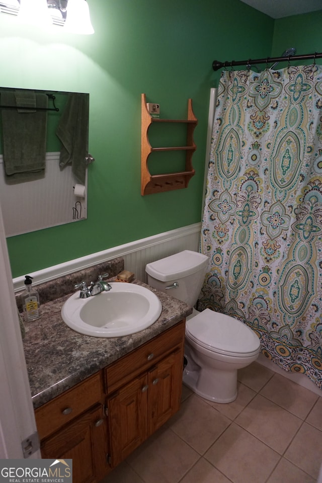 bathroom featuring vanity, toilet, walk in shower, and tile patterned flooring