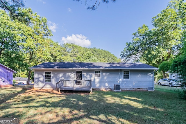 back of property with a yard, a wooden deck, and cooling unit