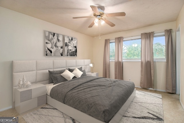 carpeted bedroom with ceiling fan and a textured ceiling