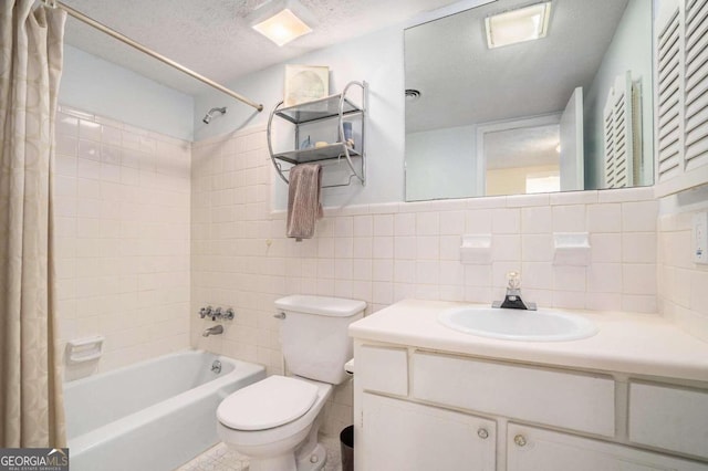 full bathroom featuring shower / tub combo, toilet, tile walls, vanity, and a textured ceiling