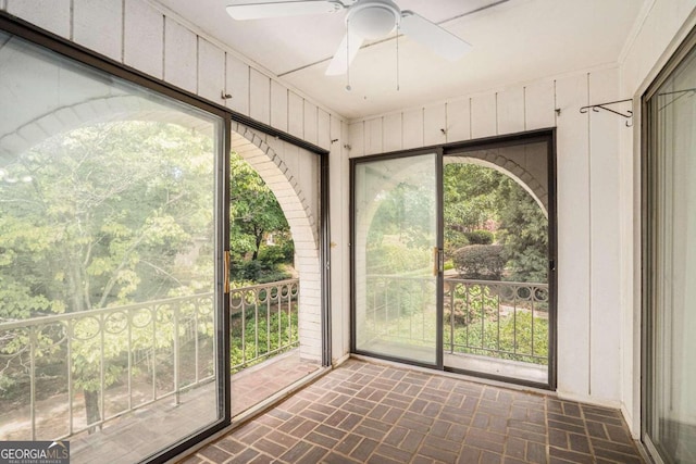 unfurnished sunroom featuring ceiling fan