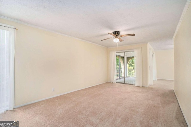 empty room featuring light carpet, a textured ceiling, ornamental molding, and ceiling fan