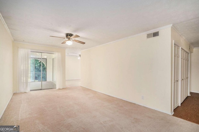 empty room with ceiling fan, carpet flooring, a textured ceiling, and ornamental molding