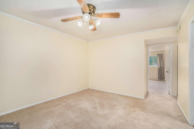 carpeted spare room featuring crown molding, ceiling fan, and a textured ceiling