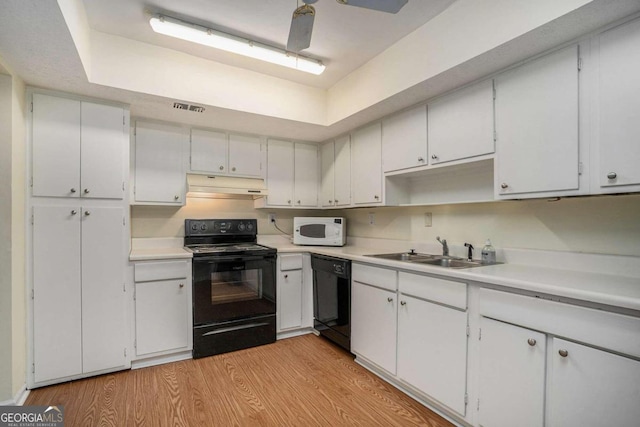 kitchen with light hardwood / wood-style floors, white cabinets, black appliances, and sink