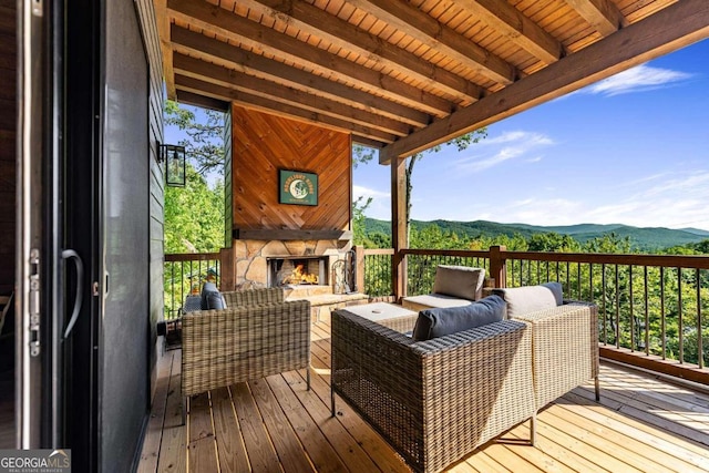 wooden deck featuring an outdoor living space with a fireplace and a mountain view