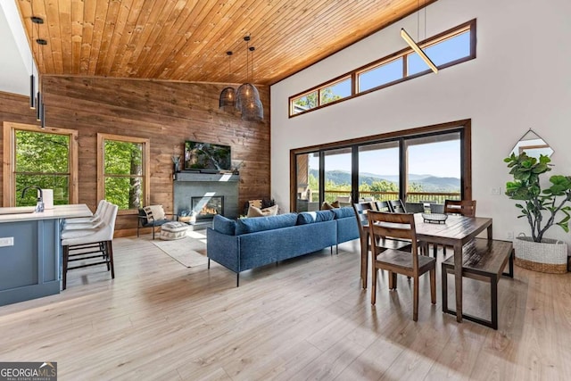 living room featuring high vaulted ceiling, wooden ceiling, and light hardwood / wood-style floors