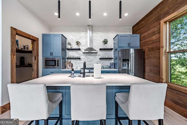 kitchen with stainless steel appliances, blue cabinets, and a healthy amount of sunlight