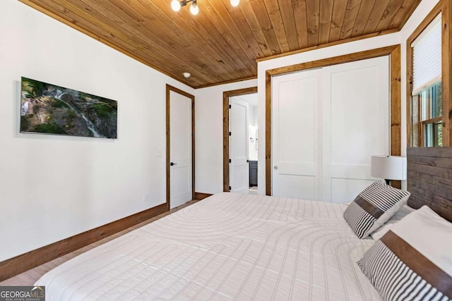 bedroom with wood ceiling, crown molding, a closet, and wood-type flooring