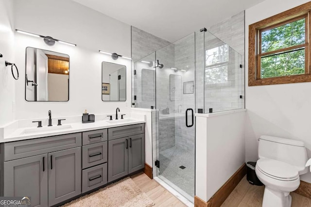 bathroom featuring an enclosed shower, wood-type flooring, toilet, and vanity