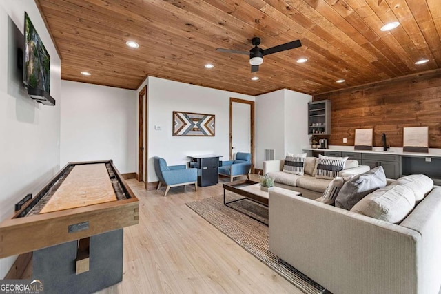 living room with ceiling fan, wood ceiling, wooden walls, and light hardwood / wood-style flooring