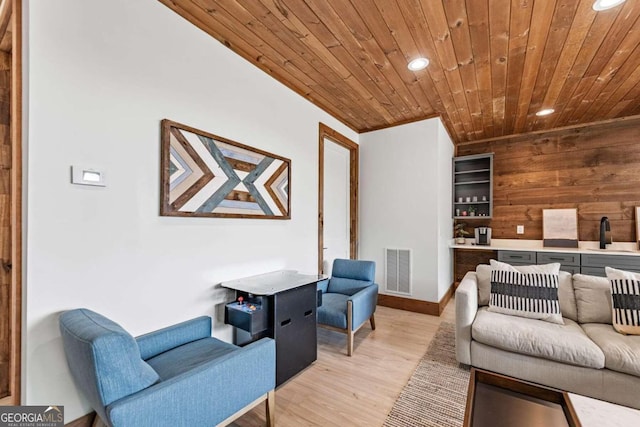 living room featuring light wood-type flooring, wood ceiling, and wood walls