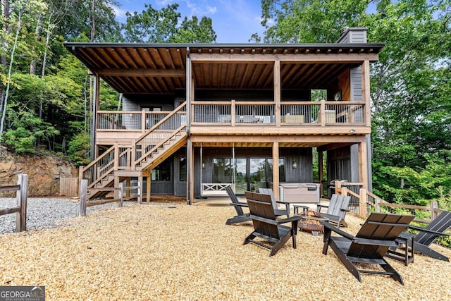 back of house with an outdoor fire pit and a deck