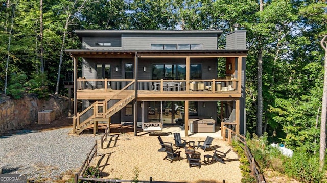 back of property featuring a jacuzzi, a wooden deck, and a patio area