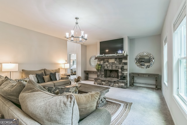 living room with carpet, a chandelier, and a stone fireplace