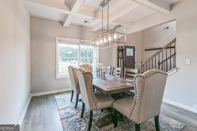 dining area featuring an inviting chandelier, beam ceiling, and dark hardwood / wood-style flooring