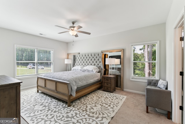 carpeted bedroom with multiple windows and ceiling fan