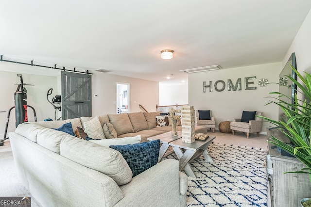 living room featuring a barn door and light carpet