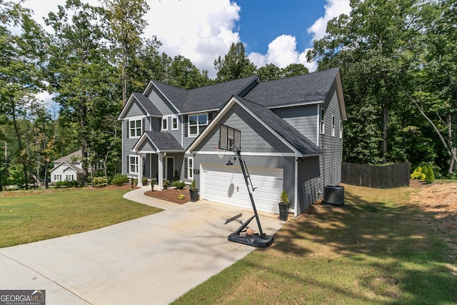 view of front of house featuring central air condition unit, a garage, and a front yard