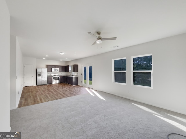 unfurnished living room featuring visible vents, a sink, recessed lighting, carpet flooring, and ceiling fan